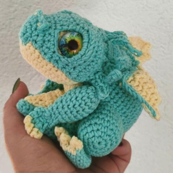 Chonks the Baby Dragon, kleiner Häkeldrache der sein Schwänzchen festhält